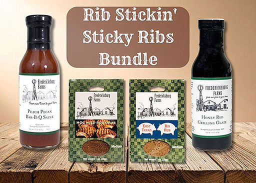 Fredericksburg Farms Rib Stickin' Sticky Ribs Bundle with two bottles of sauce and two packets on a wooden surface.